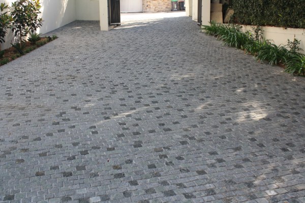 A random mix of grey cobblestones creates an elegant driveway replacing a dull concrete wasteland